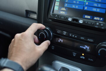 Hands that are adjusting the temperature in the car