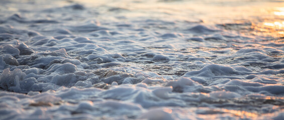 Beautiful wave with foam in the evening sea.