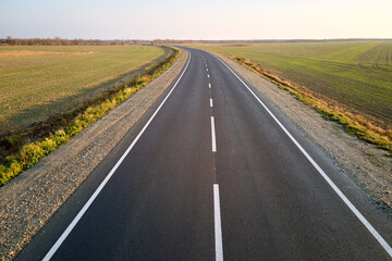 Aerial view of empty intercity road at sunset. Top view from drone of highway in evening