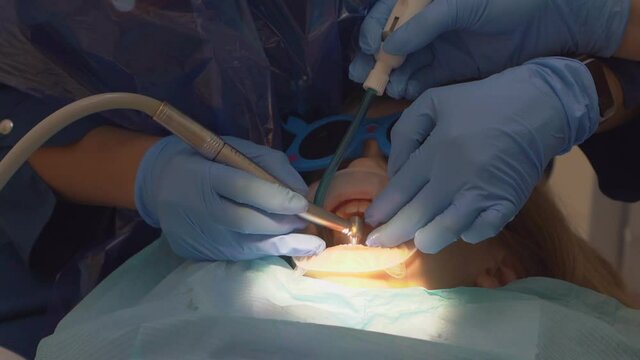 a little girl with an oral dilator at the dentist's appointment. 