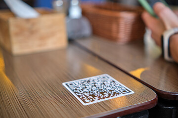 Closeup of guest hand ordering meal in restaurant while scanning qr code with mobile phone for...