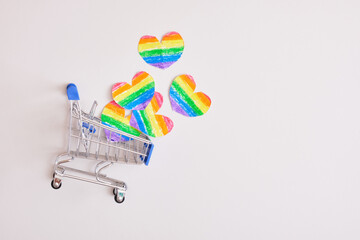 shopping cart and hearts of rainbow colors on gray background