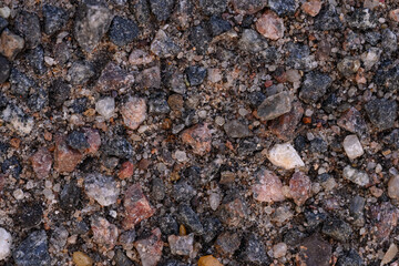 the texture of old asphalt. a lot of small stones of different colors, granite chips. close up