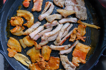 Korean traditional grilled BBQ food, samgyupsal, pork with gochujang and Grilled Pork Neck on hot pan, Food for camping in winter.