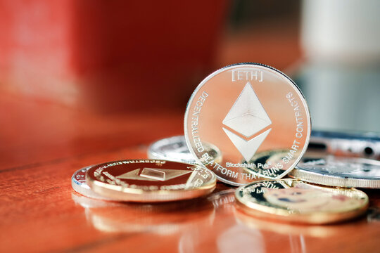 Maesot, Thailand- June 13, 2021:Ethereum coins stacked on a wooden table. Concept crypto currency virtual money.