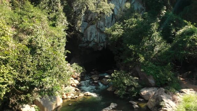 Kong Lor Cave in Laos, aerial drone view of Nam Hinboun river, fly out closeup to wide angle