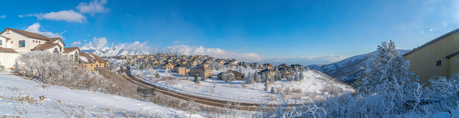 View of different houses in a snowy residential area at Draper, Utah with Wasatch Mountains' view