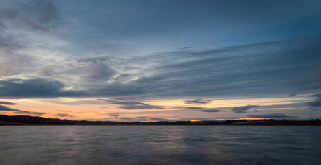 Fototapeta na wymiar Amazing dramatic sunset sky with cumulus cloud on pond Dehtar. Long exposure, Czech landscape
