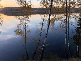 sunset on the lake in the middle of the forest in autumn