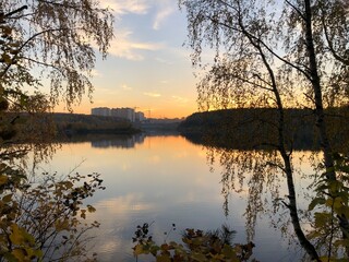 sunset on the lake in the middle of the forest in autumn