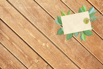 Horizontal background with eco paper label and green leaves on wooden boards