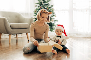 Children open Christmas presents under the Christmas tree on the morning after Christmas. The concept of Christmas and New Year