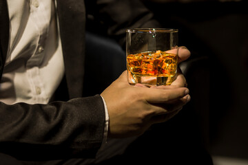 Closeup businessmen holding a glass of whiskey