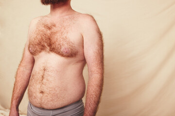 Naklejka premium Hairy man with a pot belly standing in a studio