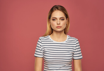 cute blonde girl in striped t-shirt emotions posing studio pink background