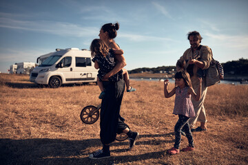 Family on a vacation, singing, playing music on a guitar and enjoying summertime vibes.