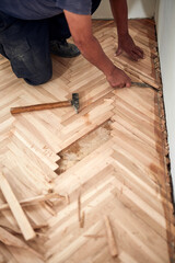 Repairman restoring old parquet hardwood floor.
