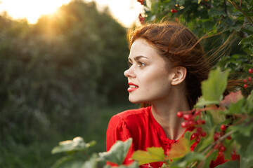 Naklejka premium pretty woman in red shirt nature green leaves summer