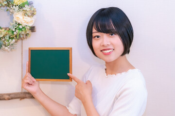 黒板を指さす女性