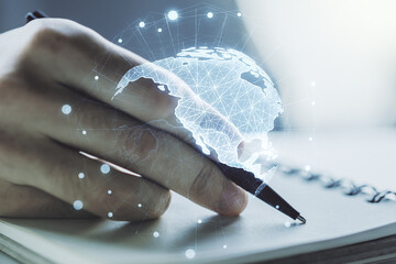 Double exposure of digital America map and man hand writing in notebook on background, research and...