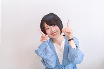 両手で上を指差す女性