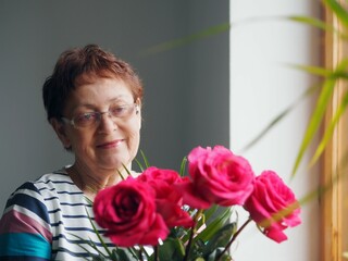 Beautiful senior woman at home with a bouquet of flowers. Happy Mother's Day. Beauty at any age.