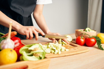 woman in apron cuts vegetables healthy food lifestyle