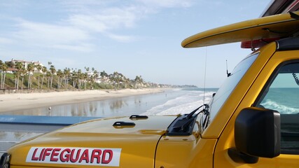 Yellow lifeguard car, San Clemente beach pier, California USA. Coastline rescue life guard pick up truck, lifesavers vehicle. Auto and ocean coast. Los Angeles vibes, summertime aesthetic atmosphere. - obrazy, fototapety, plakaty