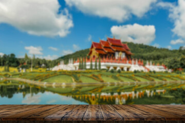 Fototapeta na wymiar Empty wooden table, blurred background of Rajapruek Park, Chiang Mai.