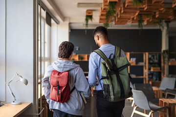 Rear view of young man with Down syndrome and his tutor indoors at school