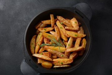Baked, fried  potato  wedges with spices and rosemary
