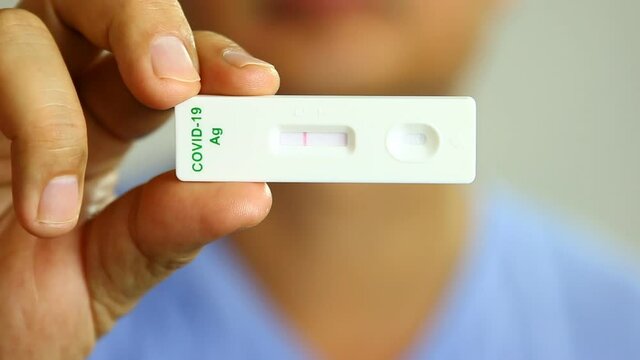 Man is showing result of  coronavirus(covid-19) rapid antigen self test kit, in studio Chiangmai  Thailand.
