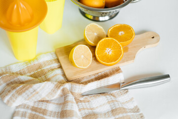 Juice of orange and lemon. A wooden board with oranges on a white table. Freshly squeezed orange juice. Lemon, orange, ginger.
