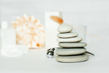 A composition of items for a spa salon. Beauty treatments and massages. Stones representing the balance of feng shui. Sea rocks and shells. Close-up, copy space, white background.