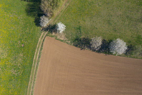 Drone view of corner of plowed field in spring