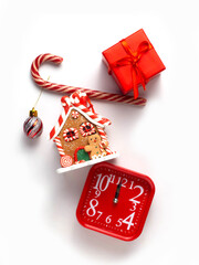 Gingerbread house, red clock, gift, candy, lollipop on a white background.