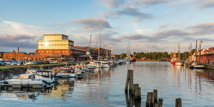 Germany, Schleswig-Holstein, Lubeck, Panoramic view of boats moored along river Trave canal at dusk