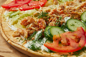 Open shawarma with meat, vegetables and cheese on a pita. Selective focus, close-up