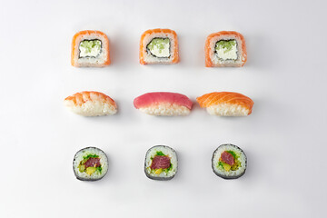 Pattern of different types of sushi rolls with tuna and salmon on a white background
