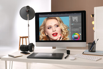 Retoucher's workplace. Computer with photo editor application, camera, smartphone and graphic...