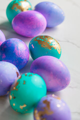 Fototapeta na wymiar Easter eggs purple and blue with golds on marble background.