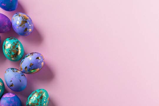 Easter eggs purple and blue with golds on pink background. - Powered by Adobe