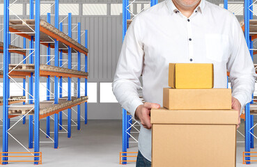 Warehouse manager with boxes. Concept - work in warehouse business. Empty pallet racks in...