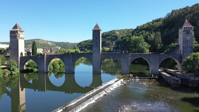 Picturesque summer drone view of ancient fortified stone arch bridge Pont Valentre crossing Lot River in Cahors, Occitanie, France