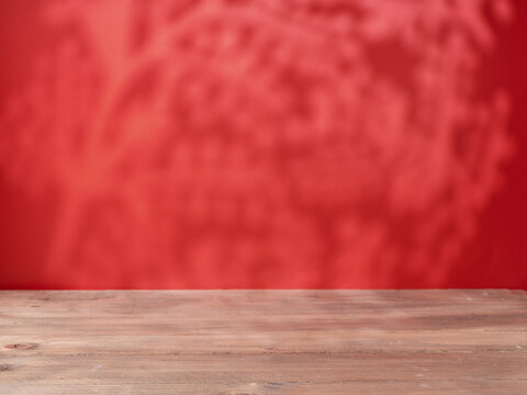 Empty wooden table on red wall background