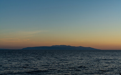 view of the Bay of Kvarna with the silhouette of Cres Island at sunset