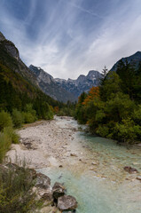 landscape in Triglav National Park in late autumn with colorful foliage and the Soca River in the foreground