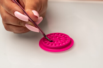 Eyelash extension tools. Fake eyelashes. Accessories for eyelash extensions. Drop of eyelash glue and curve tweezers. Eyelash extension procedure.