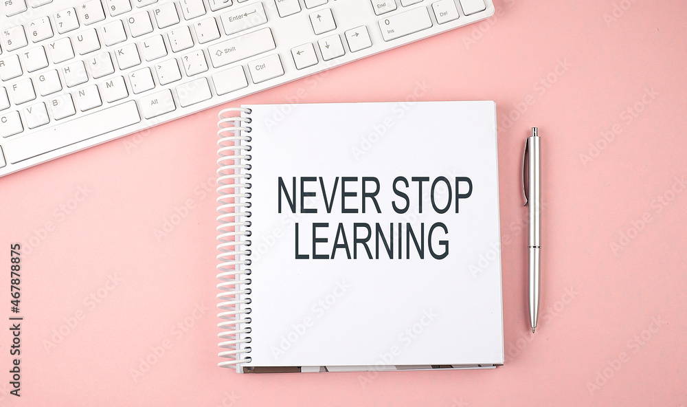 Poster pink office desk with keyboard and notebook with text never stop learning
