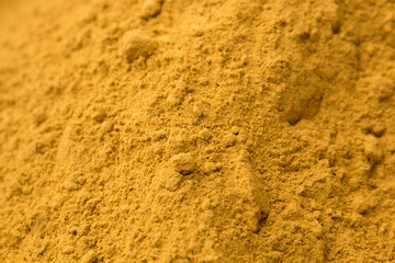 Fototapeta na wymiar Seasoning yellow turmeric. Sand texture. Wallpaper.